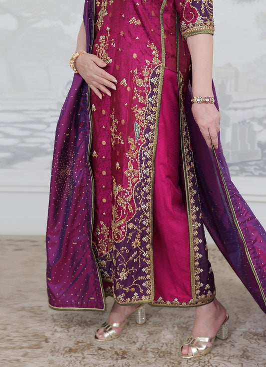Farah Talib Aziz Bita magenta pure silk kurta featuring intricate hand embellishments with resham, zari, and sequins on the neckline, sleeves, daaman, and borders, paired with a luxurious purple tissue chaadar richly worked with golden embellishments and subtle shimmer accents, perfect for festive gatherings and formal occasions.