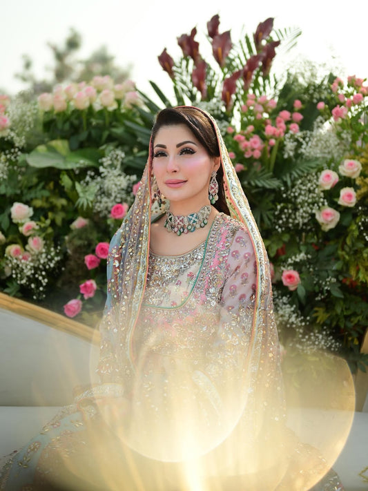 Nomi Ansari pastel princess-style lehenga choli inspired by Maryam Nawaz viral wedding look in soft blush pink and mint tones layered over a powder base, featuring delicate handcrafted embellishments with a floaty lightweight dupatta that creates a dreamy silhouette, perfect for valima receptions, engagement ceremonies, and bridesmaids