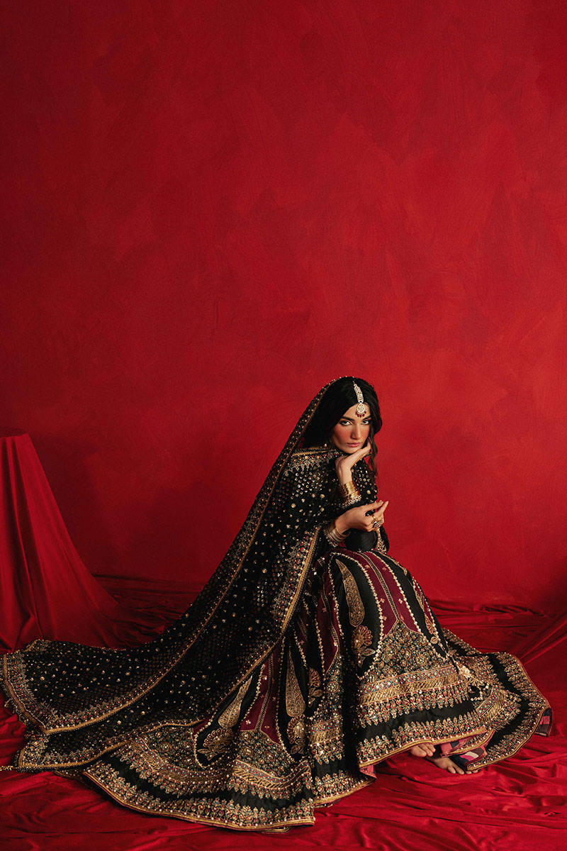 Mohsin Naveed Ranjha Dil Raas black Indian silk lehenga choli featuring a full-sleeved choli with metallic and silk thread embroidery in star-like patterns, paired with a lehenga in deep maroon fading to black with embroidered cypress trees, palmette motifs, mirrorwork, sequins, and golden thread detailing, finished with maroon and gold layered borders, complete with a lightweight organza dupatta featuring maroon and gold floral sprays, gota pati, and adda work, perfect for bridal wear and formal celebratio
