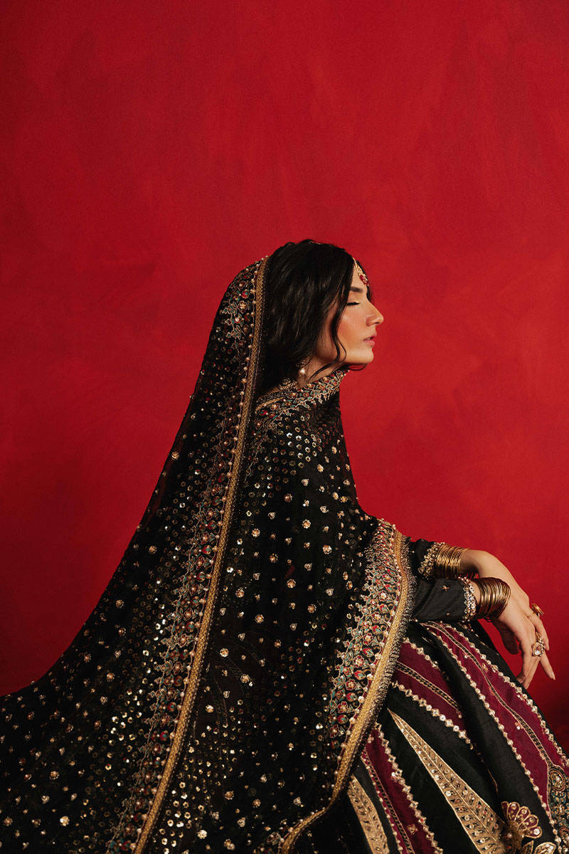Mohsin Naveed Ranjha Dil Raas black Indian silk lehenga choli featuring a full-sleeved choli with metallic and silk thread embroidery in star-like patterns, paired with a lehenga in deep maroon fading to black with embroidered cypress trees, palmette motifs, mirrorwork, sequins, and golden thread detailing, finished with maroon and gold layered borders, complete with a lightweight organza dupatta featuring maroon and gold floral sprays, gota pati, and adda work, perfect for bridal wear and formal celebratio