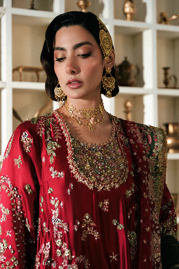 Suffuse Afsanae red bridal maxi dress featuring intricate hand embroidery with detailed floral and botanical motifs in gold and silver threadwork, paired with a heavily embellished red dupatta with ornate borders and a contrasting deep green velvet shawl, perfect for nikah, barat, reception, and formal wedding events.