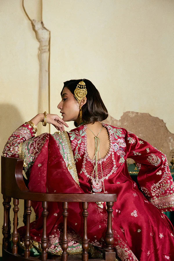 Suffuse Afsanae red bridal maxi dress featuring intricate hand embroidery with detailed floral and botanical motifs in gold and silver threadwork, paired with a heavily embellished red dupatta with ornate borders and a contrasting deep green velvet shawl, perfect for nikah, barat, reception, and formal wedding events.