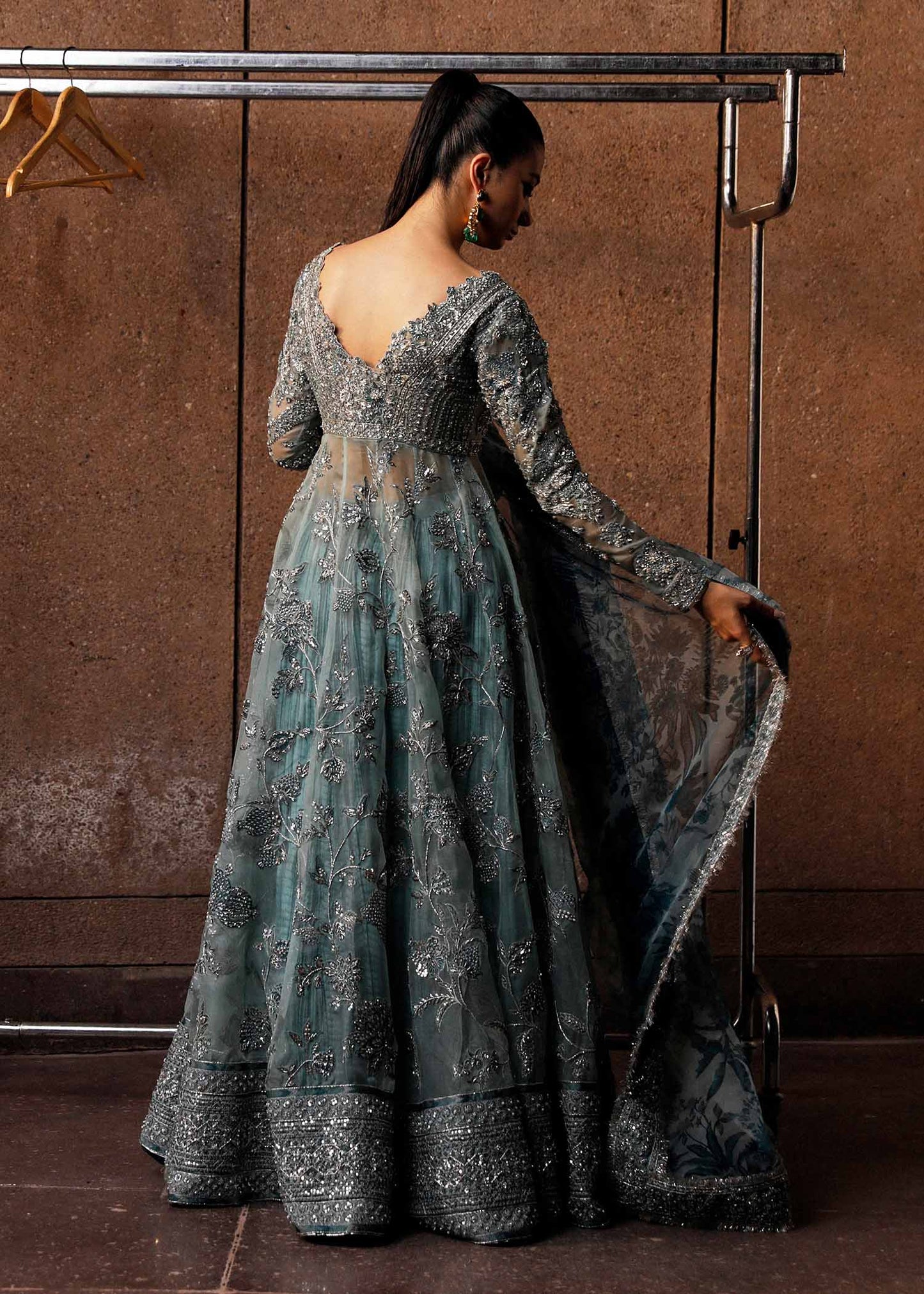  Hussain Rehar Astra ice-blue organza peshwas featuring intricate embellishments on the front and back bodice with heavy embellished borders, paired with a resplendent silk crushed sharara and a digital printed organza dupatta with celestial motifs and four-sided embellished border, perfect for weddings and formal celebrations.
