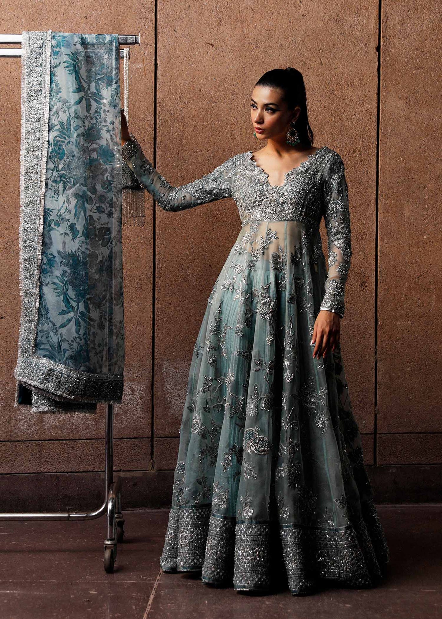  Hussain Rehar Astra ice-blue organza peshwas featuring intricate embellishments on the front and back bodice with heavy embellished borders, paired with a resplendent silk crushed sharara and a digital printed organza dupatta with celestial motifs and four-sided embellished border, perfect for weddings and formal celebrations.
