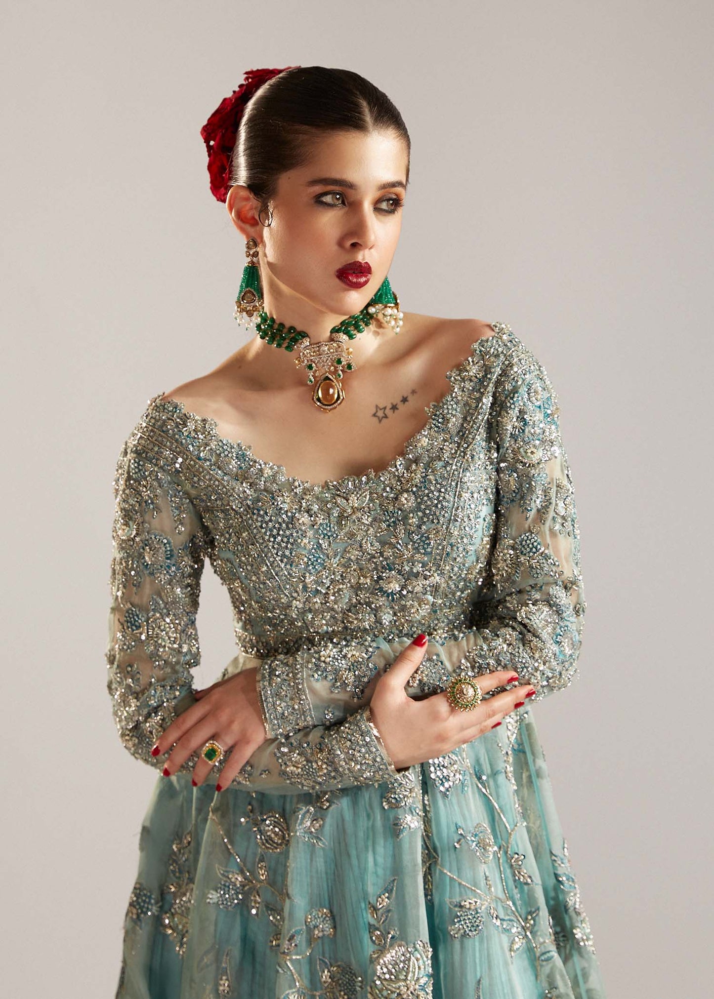  Hussain Rehar Astra ice-blue organza peshwas featuring intricate embellishments on the front and back bodice with heavy embellished borders, paired with a resplendent silk crushed sharara and a digital printed organza dupatta with celestial motifs and four-sided embellished border, perfect for weddings and formal celebrations.
