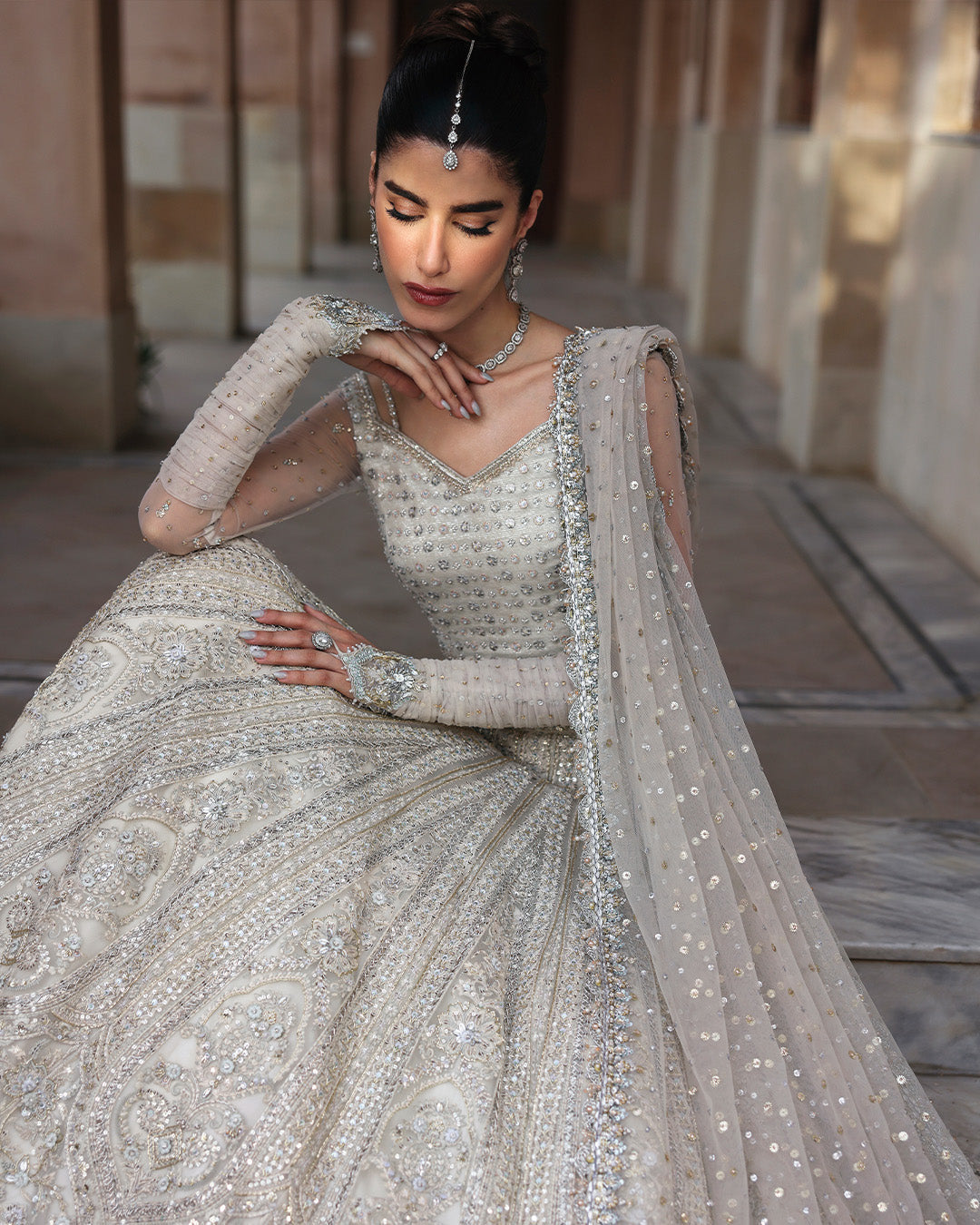 Faiza Saqlain Cammi soft ivory ensemble featuring intricately handworked detailing and delicate embellishments on a flowing silhouette, paired with a sheer dupatta, perfect for weddings and formal occasions.