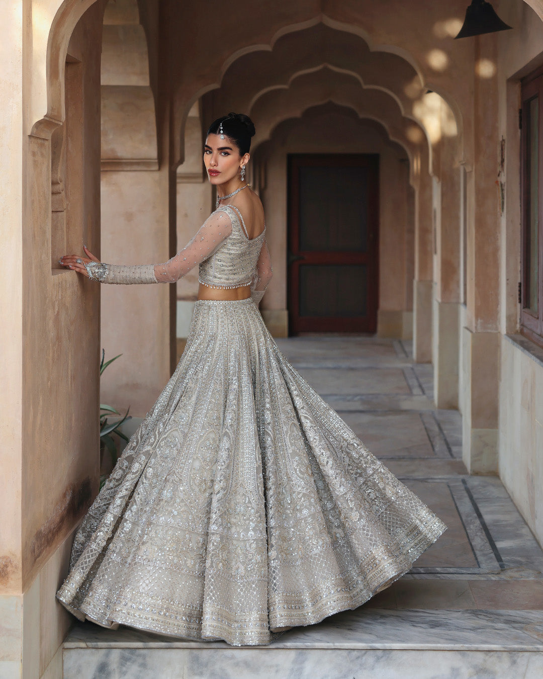Faiza Saqlain Cammi soft ivory ensemble featuring intricately handworked detailing and delicate embellishments on a flowing silhouette, paired with a sheer dupatta, perfect for weddings and formal occasions.
