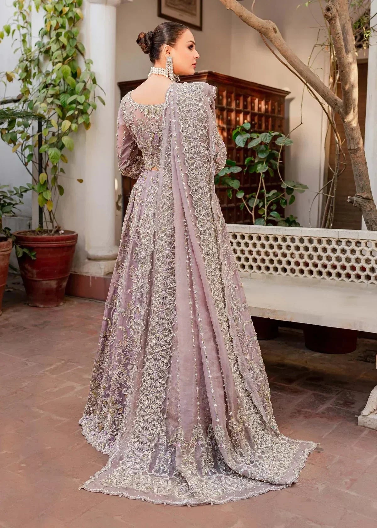 Kanwal Malik Zaarish lilac organza lehenga choli featuring heavy embroidery and hand embellishments with naqshi, dabka, crystals, pearls, and sequin in a blend of floral and geometrical patterns, paired with an organza dupatta adorned with a four-sided embellished border and vertical embellished lines at the center with extended pallu, perfect for weddings and formal occasions.