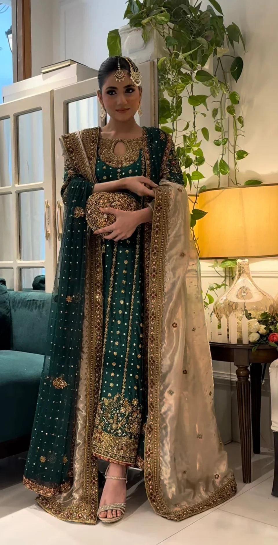  Mehru deep emerald ensemble featuring antique gold and subtle maroon accents with a matching green dupatta edged in ornate red and maroon borders, creating a regal look steeped in timeless tradition and quiet grandeur.