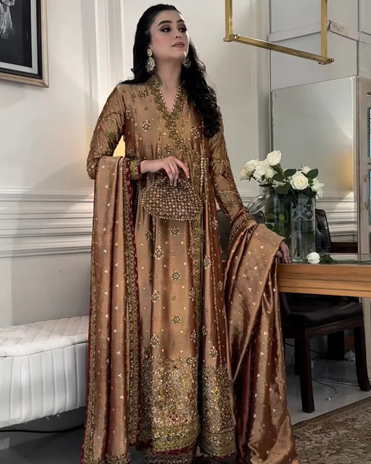 Haris Shakeel Aswad bronze-gold formal ensemble featuring intricate hand embellishments with detailed floral motifs, delicate sequins, and refined accents on an elongated silhouette with a heavily worked hemline, perfect for weddings, receptions, formal dinners, and festive celebrations.