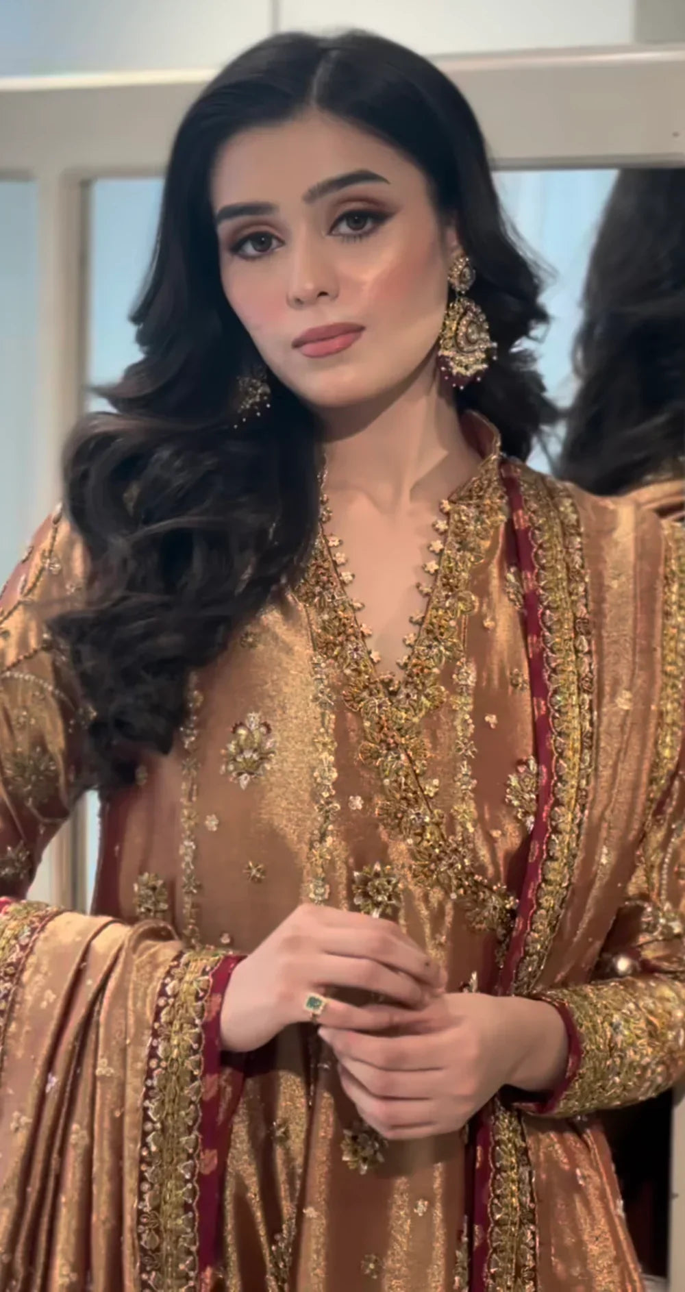 Haris Shakeel Aswad bronze-gold formal ensemble featuring intricate hand embellishments with detailed floral motifs, delicate sequins, and refined accents on an elongated silhouette with a heavily worked hemline, perfect for weddings, receptions, formal dinners, and festive celebrations.