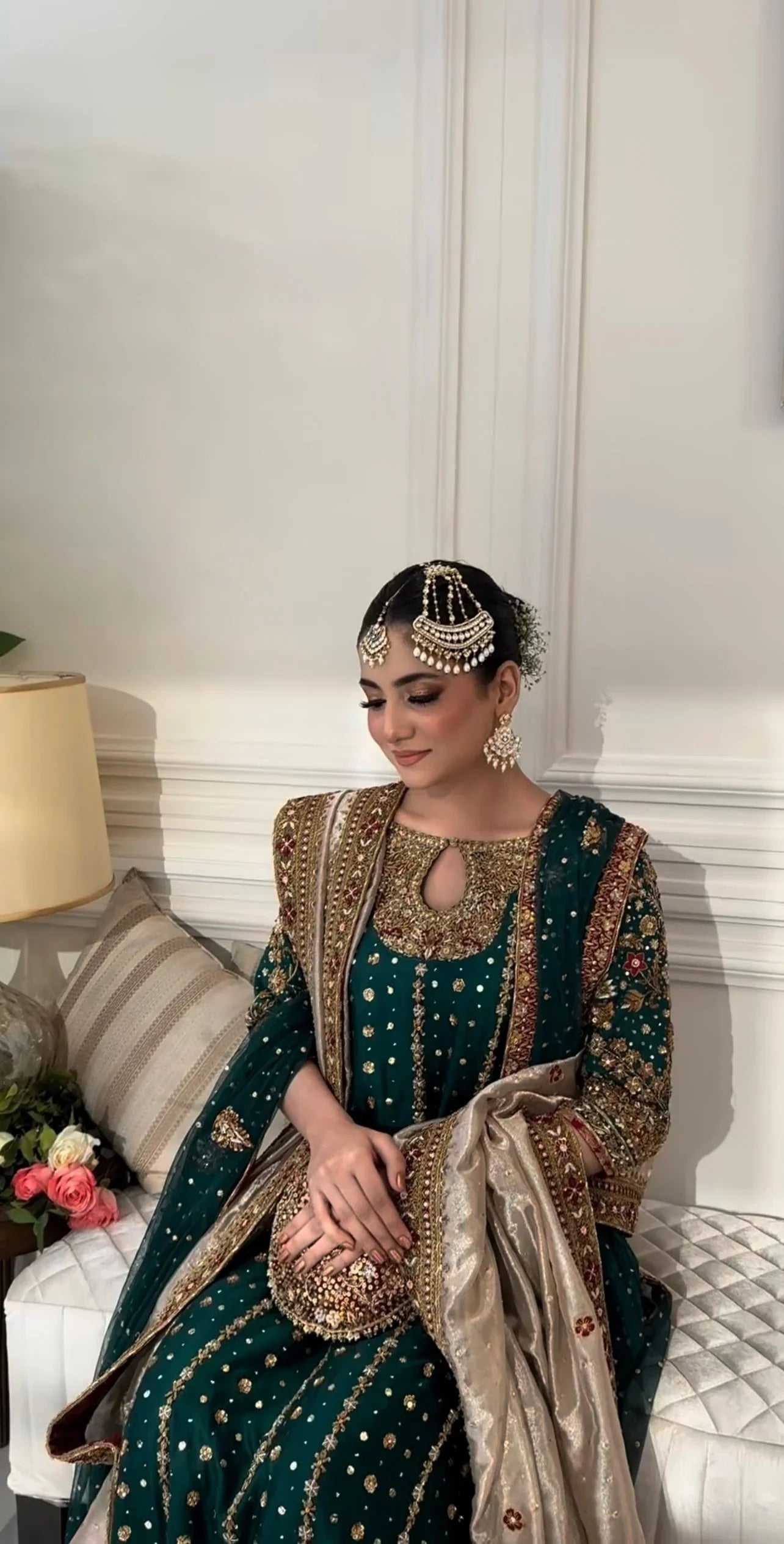  Mehru deep emerald ensemble featuring antique gold and subtle maroon accents with a matching green dupatta edged in ornate red and maroon borders, creating a regal look steeped in timeless tradition and quiet grandeur.