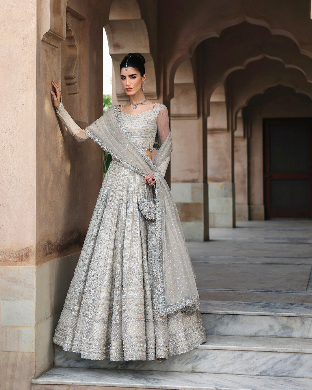 Faiza Saqlain Cammi soft ivory ensemble featuring intricately handworked detailing and delicate embellishments on a flowing silhouette, paired with a sheer dupatta, perfect for weddings and formal occasions.