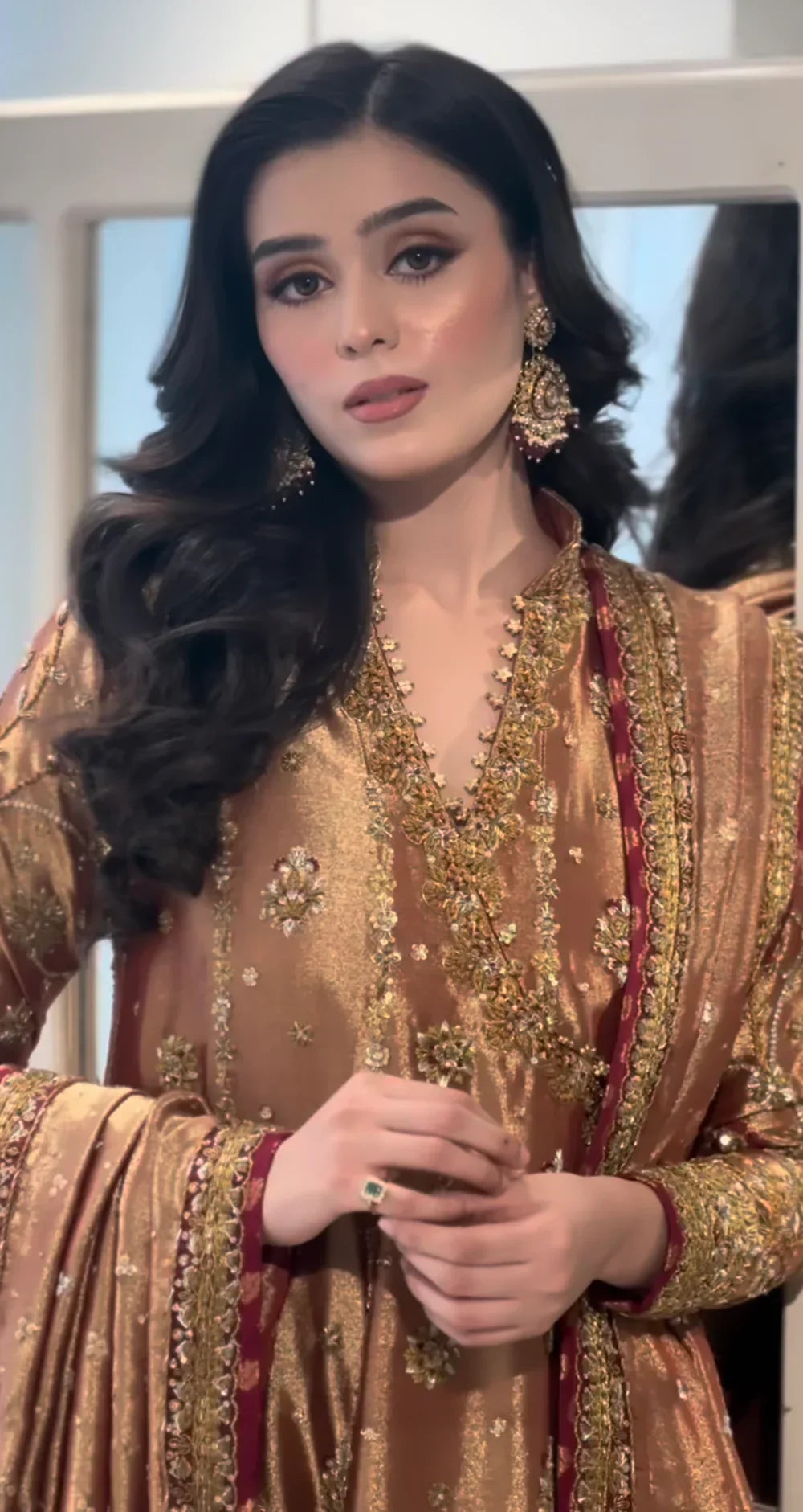 Haris Shakeel Aswad bronze-gold formal ensemble featuring intricate hand embellishments with detailed floral motifs, delicate sequins, and refined accents on an elongated silhouette with a heavily worked hemline, perfect for weddings, receptions, formal dinners, and festive celebrations.