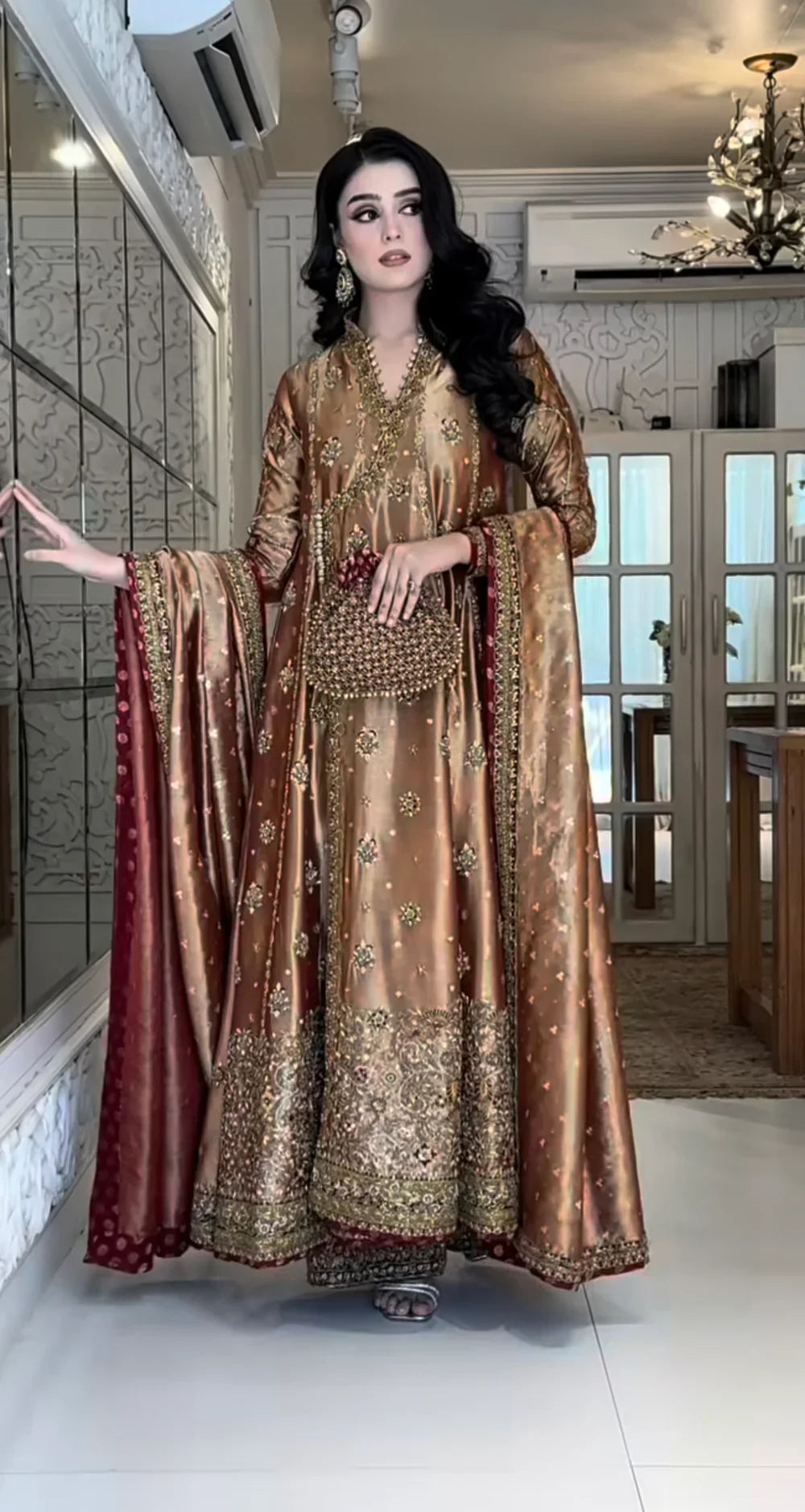 Haris Shakeel Aswad bronze-gold formal ensemble featuring intricate hand embellishments with detailed floral motifs, delicate sequins, and refined accents on an elongated silhouette with a heavily worked hemline, perfect for weddings, receptions, formal dinners, and festive celebrations.
