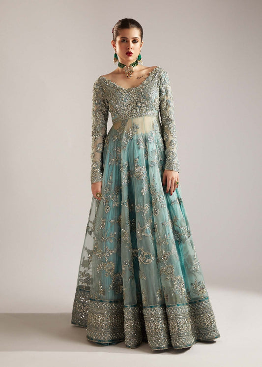  Hussain Rehar Astra ice-blue organza peshwas featuring intricate embellishments on the front and back bodice with heavy embellished borders, paired with a resplendent silk crushed sharara and a digital printed organza dupatta with celestial motifs and four-sided embellished border, perfect for weddings and formal celebrations.

