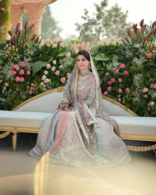 Nomi Ansari pastel princess-style lehenga choli inspired by Maryam Nawaz viral wedding look in soft blush pink and mint tones layered over a powder base, featuring delicate handcrafted embellishments with a floaty lightweight dupatta that creates a dreamy silhouette, perfect for valima receptions, engagement ceremonies, and bridesmaids