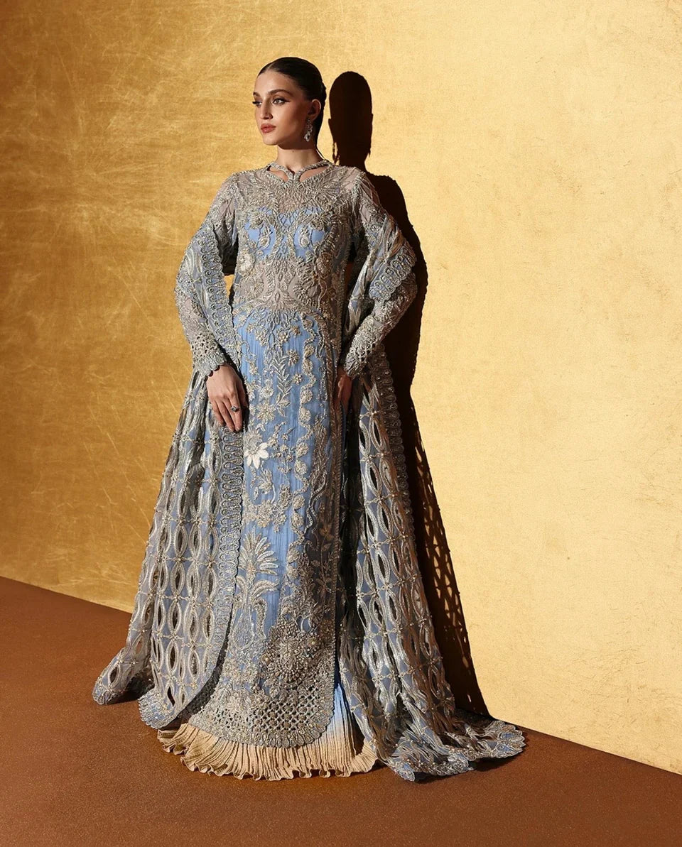 Soraya inspired Seralyn luxury formal ensemble in a soft ethereal pastel palette with subtle warm undertones featuring intricate hand embellishments and shimmering accents on a flowing silhouette with a richly worked bodice and embellished flare, paired with a coordinated dupatta with elegant borders, perfect for weddings and formal celebrations.