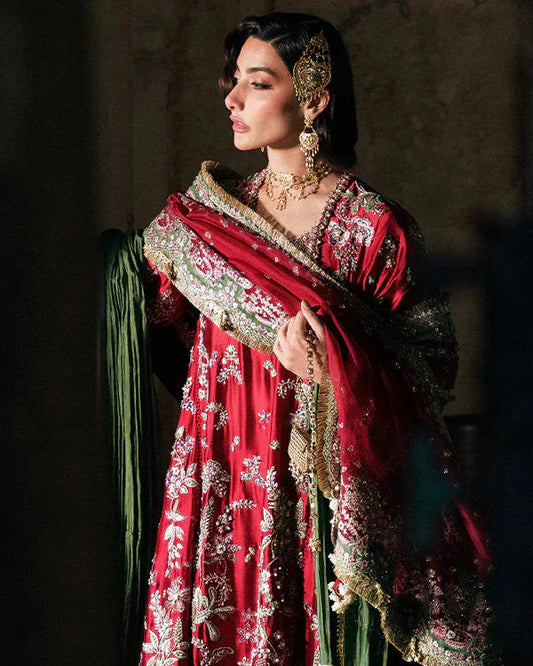 Suffuse Afsanae red bridal maxi dress featuring intricate hand embroidery with detailed floral and botanical motifs in gold and silver threadwork, paired with a heavily embellished red dupatta with ornate borders and a contrasting deep green velvet shawl, perfect for nikah, barat, reception, and formal wedding events.
