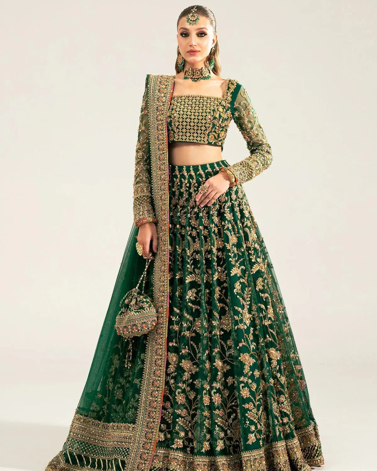  Kanwal Malik Sukhan bottle green net lehenga choli featuring an intricately embellished choli and flowing lehenga with a floral jaal design in vibrant orange and pink accents, enhanced with gold, gotta, and silver embellishments, complete with a matching net dupatta with an embellished border, perfect for weddings and festive occasions.