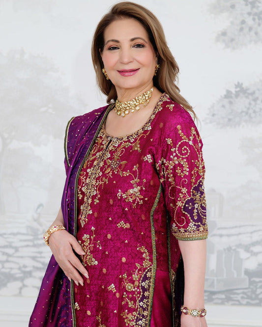 Farah Talib Aziz Bita magenta pure silk kurta featuring intricate hand embellishments with resham, zari, and sequins on the neckline, sleeves, daaman, and borders, paired with a luxurious purple tissue chaadar richly worked with golden embellishments and subtle shimmer accents, perfect for festive gatherings and formal occasions.