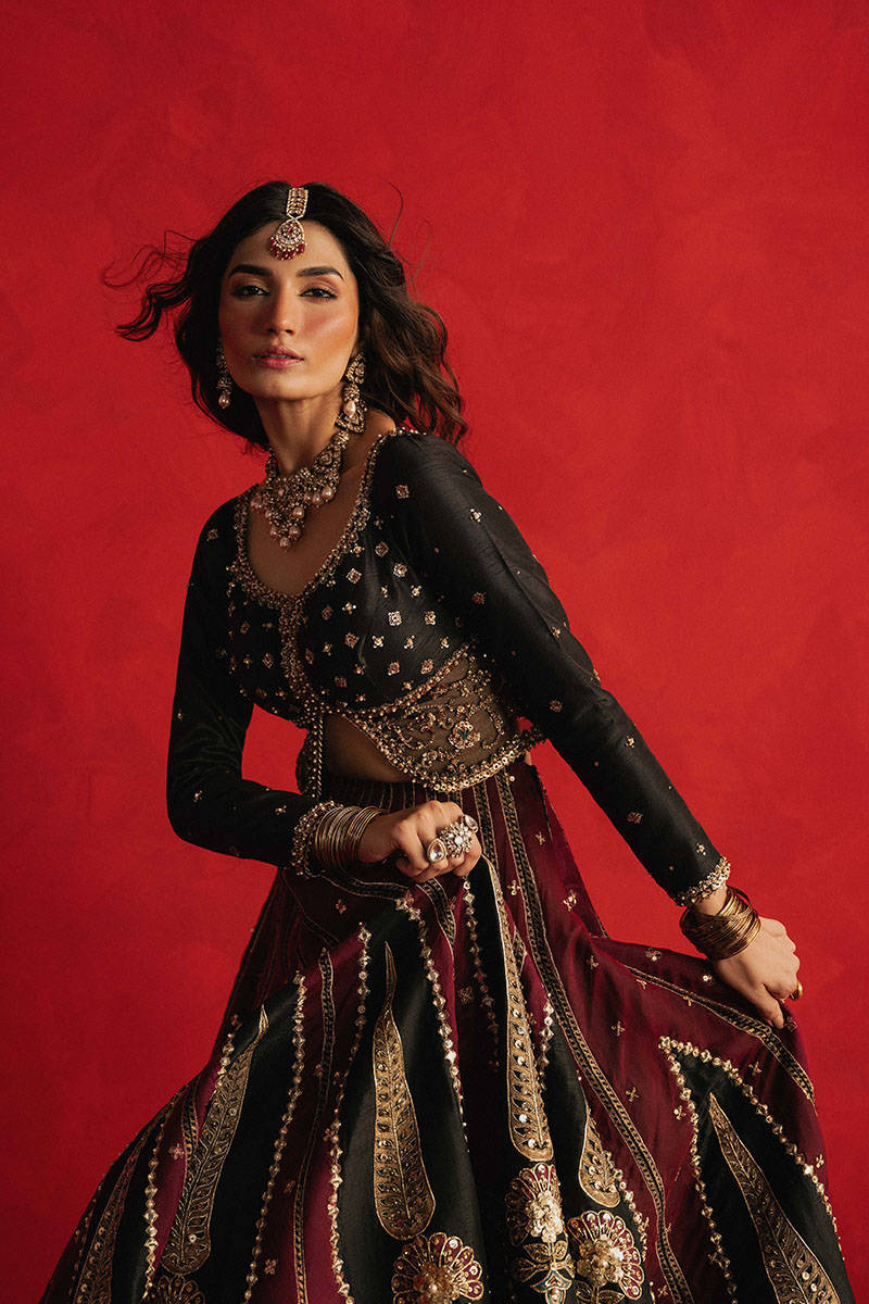 Mohsin Naveed Ranjha Dil Raas black Indian silk lehenga choli featuring a full-sleeved choli with metallic and silk thread embroidery in star-like patterns, paired with a lehenga in deep maroon fading to black with embroidered cypress trees, palmette motifs, mirrorwork, sequins, and golden thread detailing, finished with maroon and gold layered borders, complete with a lightweight organza dupatta featuring maroon and gold floral sprays, gota pati, and adda work, perfect for bridal wear and formal celebratio