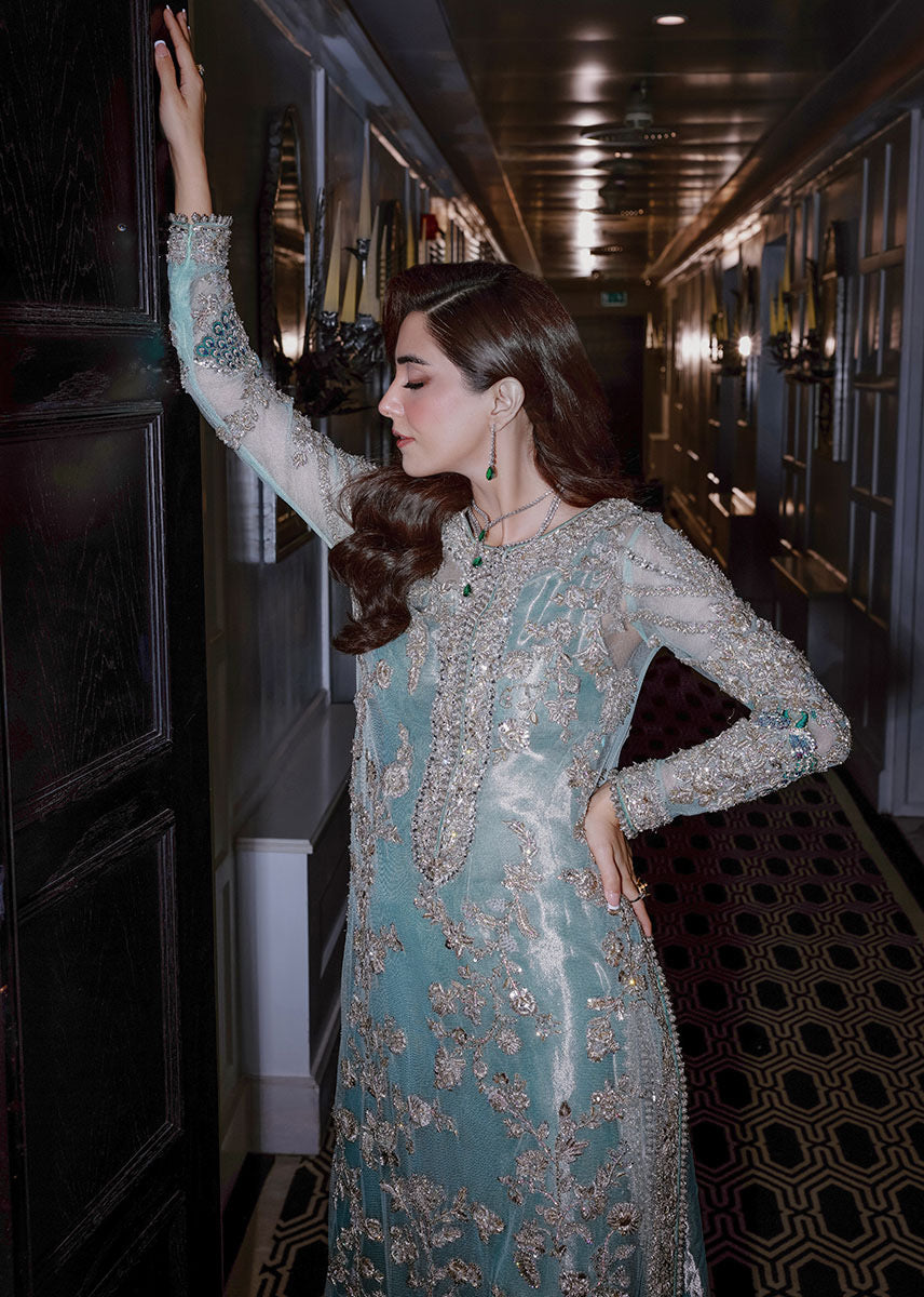 Sara Rohale Asghar Ferozeah aqua long shirt featuring intricate silver embellishments with hand-embroidered floral motifs creating a refined jal, paired with a sheer dupatta with heavily embellished border and scattered sequins, and straight-cut azar trousers with bejeweled peacock hem in silver threadwork, perfect for formal occasions and statement looks.